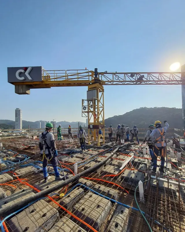Equipe da FC trabalhando sobre a laje, com a grua ao fundo