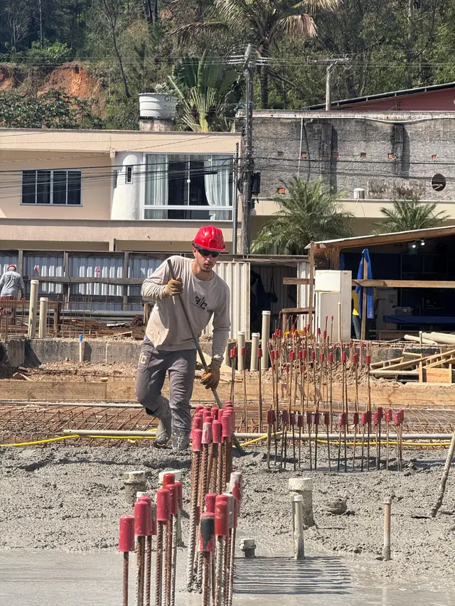 Esperas de aço com tampas vermelhas sobre a fundação concretada