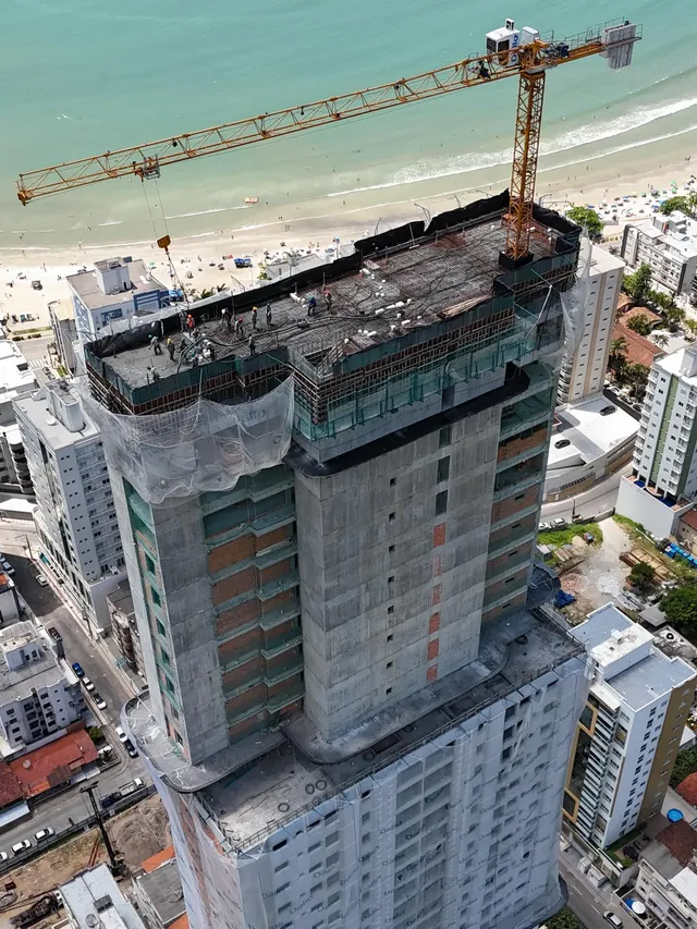 Vista aérea da torre Montreux em obra, com a grua no topo e a praia ao fundo